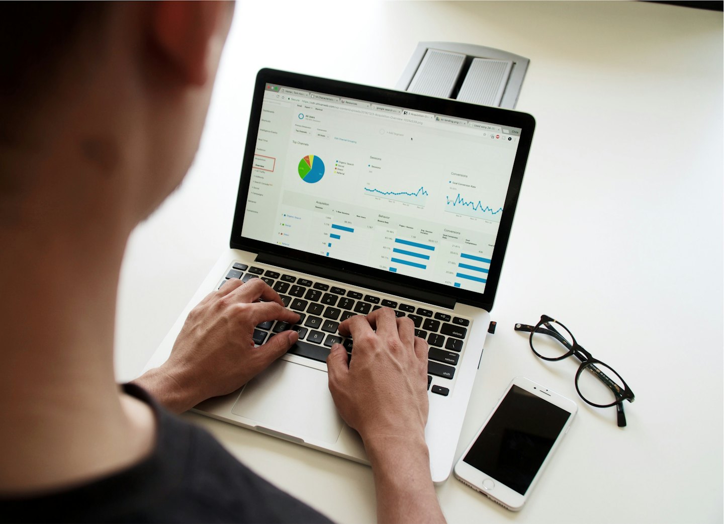 Person typing on a laptop with data analytics dashboard.