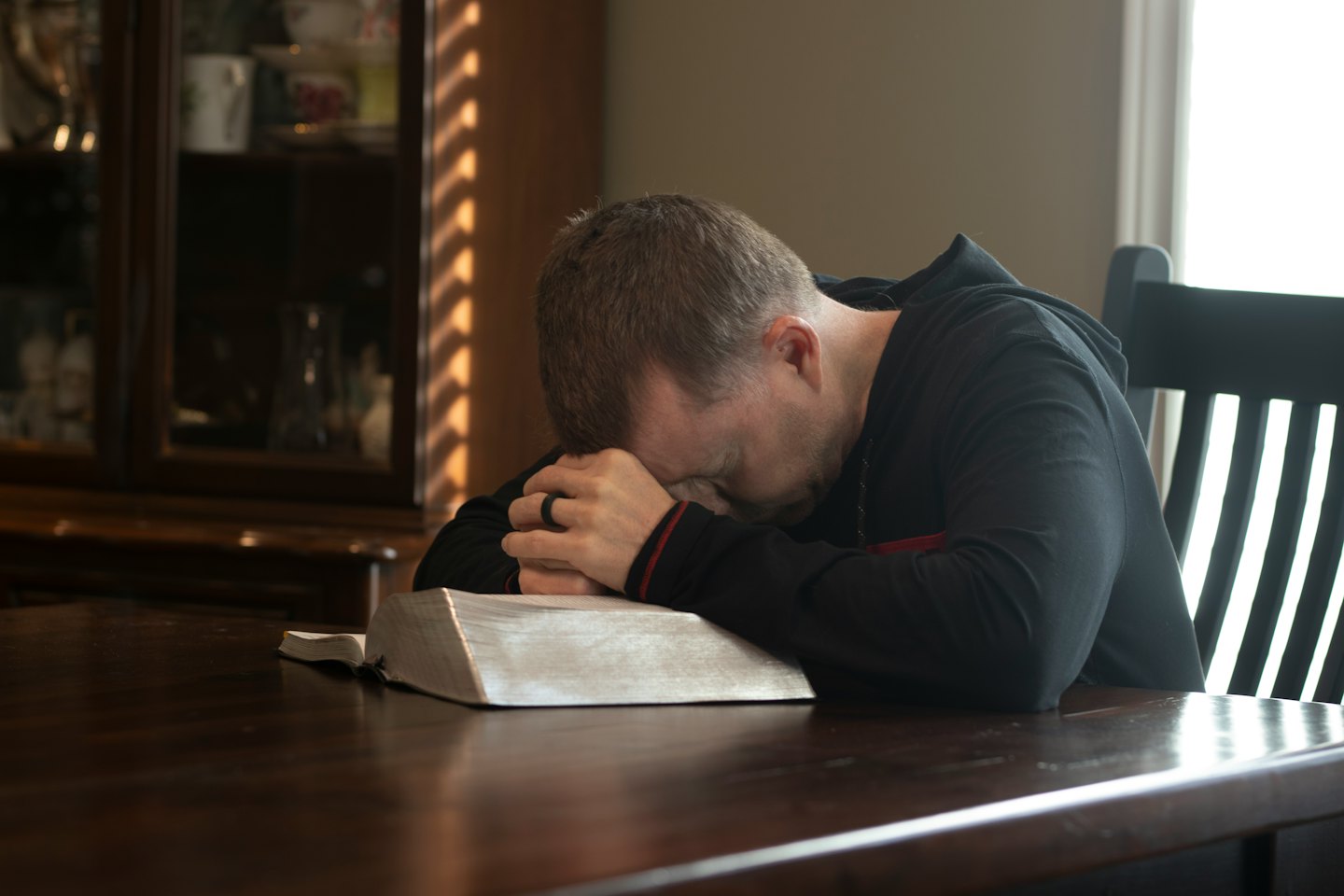Man resting his head on his hands over an open book.