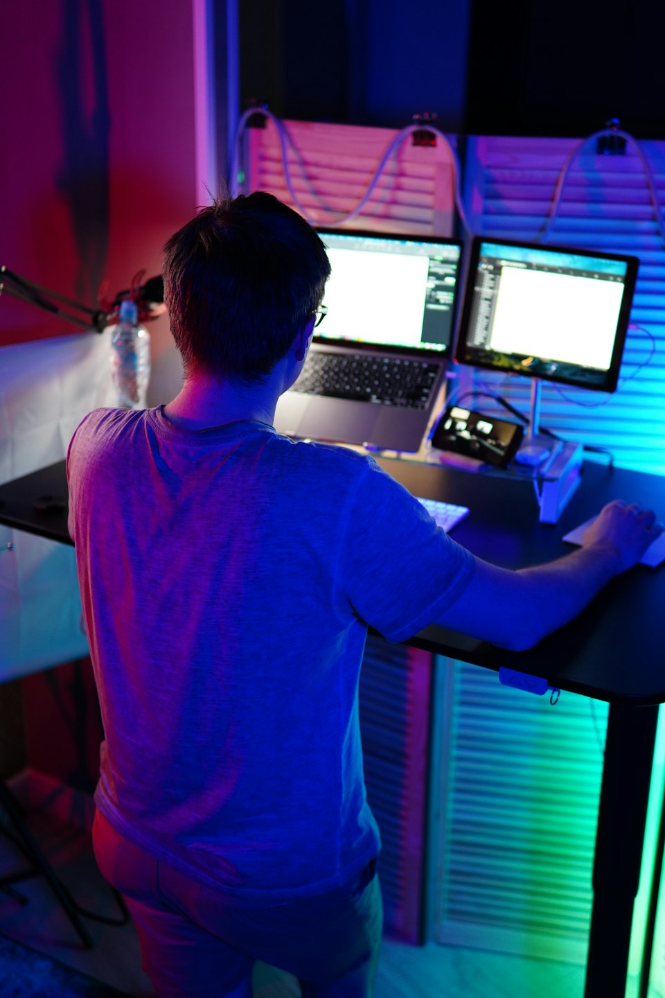 Person working at a desk with laptop and monitor.