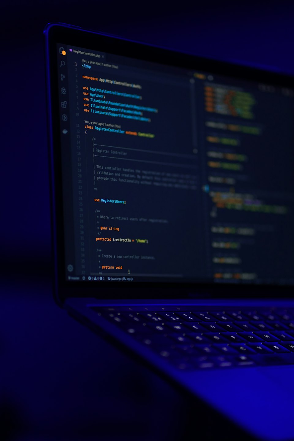 Laptop screen displays lines of code in a dark room.